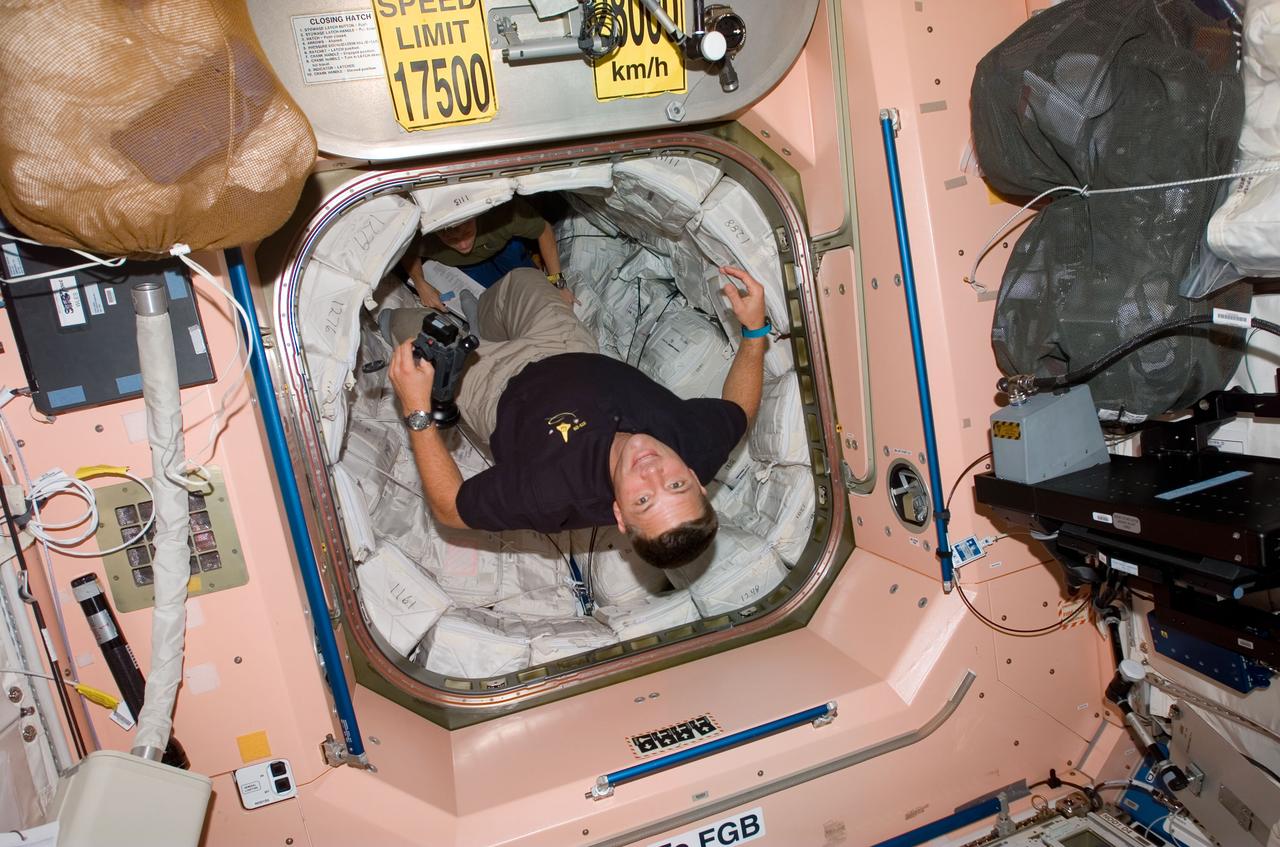 S120-E-006435 (25 Oct. 2007) --- Astronaut Doug Wheelock, STS-120 mission specialist, floats into the Unity node of the International Space Station while Space Shuttle Discovery is docked with the station.