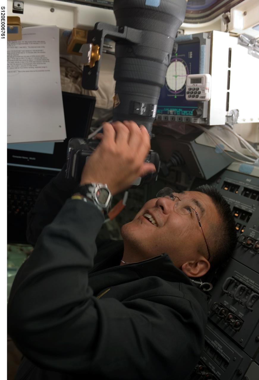 S120-E-006761 (25 Oct. 2007) --- Astronaut Daniel Tani, STS-120 mission specialist, appears to like what he sees through the viewfinder of his camera aimed through windows on the flight deck of the Space Shuttle Discovery. Shortly afterward, Discovery was docked with the International Space Station, which will be Tani's home and work place for the next several months as he switches roles to serve as Expedition 16 flight engineer.