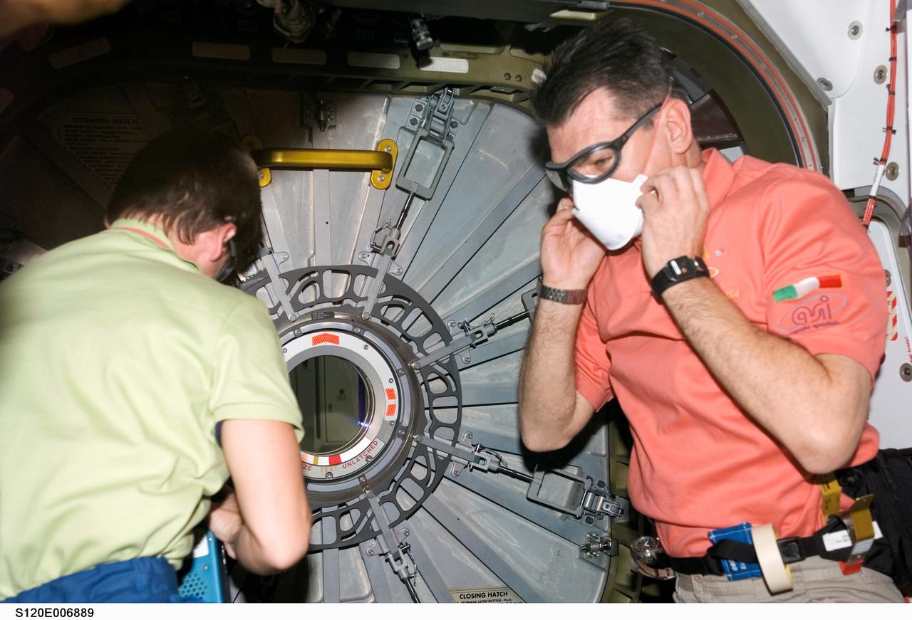 S120-E-006889 (27 Oct. 2007) --- Astronauts Peggy A. Whitson (left), Expedition 16 commander, and European Space Agency's (ESA) Paolo Nespoli, STS-120 mission specialist, prepare to open the hatch to the Harmony node -- the newest additional to the International Space Station -- while Space Shuttle Discovery is docked with the station.