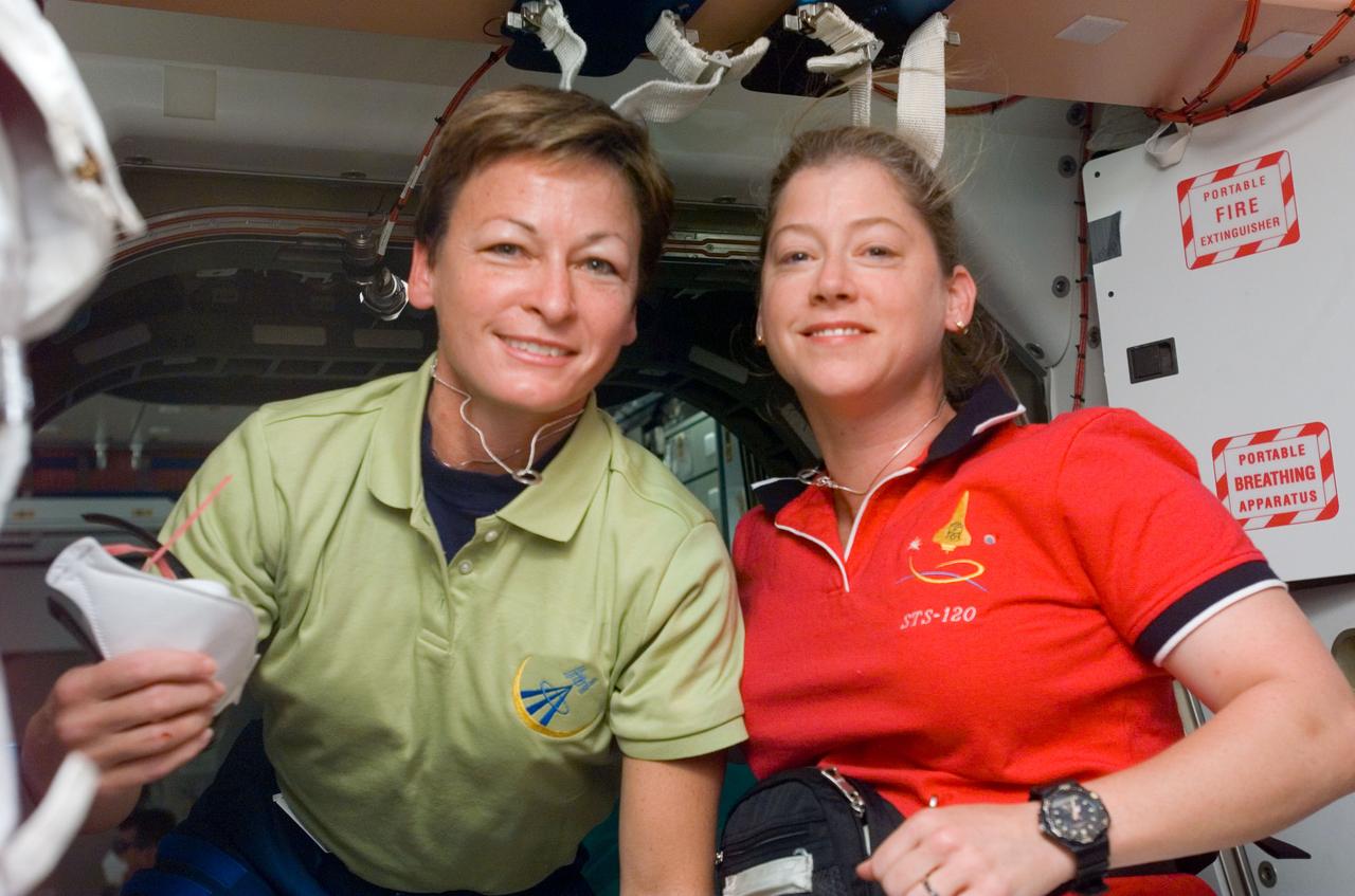 S120-E-006955 (27 Oct. 2007) --- Astronaut Peggy A. Whitson (left), Expedition 16 commander, and Pam Melroy, STS-120 commander, take a moment for a photo in the Unity node of the International Space Station while Space Shuttle Discovery is docked with the station. The joint mission of the two marks the first time both spacecraft have been commanded by females simultaneously.