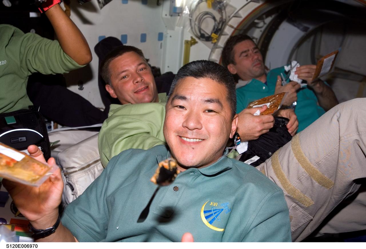 S120-E-006970 (27 Oct. 2007) --- STS-120 and Expedition 16 crewmembers share a meal on the middeck of Space Shuttle Discovery while docked with the International Space Station. Pictured are astronauts Daniel Tani (foreground), Expedition 16 flight engineer; Doug Wheelock, STS-120 mission specialist; and cosmonaut Yuri I. Malenchenko (right background), Expedition 16 flight engineer representing Russia's Federal Space Agency.