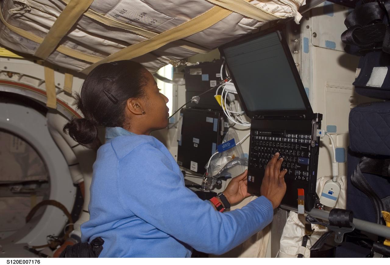 S120-E-007176 (29 Oct. 2007) --- Astronaut Stephanie Wilson, STS-120 mission specialist, uses a computer on the middeck of Space Shuttle Discovery while docked with the International Space Station during flight day seven activities.