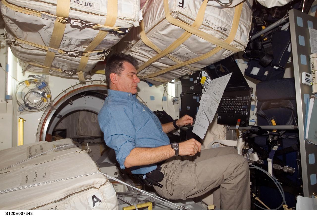 S120-E-007343 (29 Oct. 2007) --- European Space Agency (ESA) astronaut Paolo Nespoli, STS-120 mission specialist, looks over procedures checklists on the middeck of Space Shuttle Discovery while docked with the International Space Station.