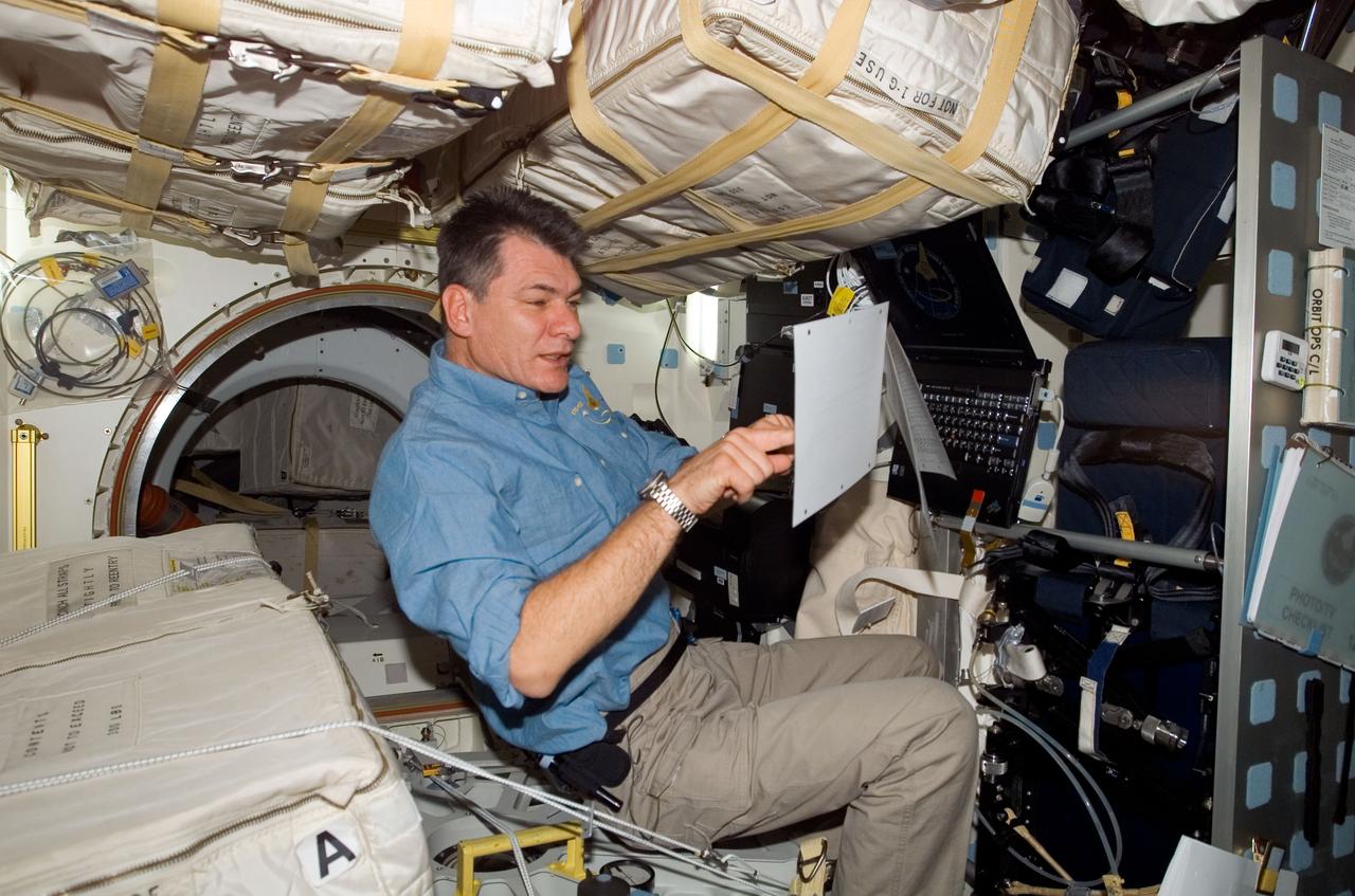 S120-E-007346 (29 Oct. 2007) --- European Space Agency (ESA) astronaut Paolo Nespoli, STS-120 mission specialist, looks over procedures checklists on the middeck of Space Shuttle Discovery while docked with the International Space Station.