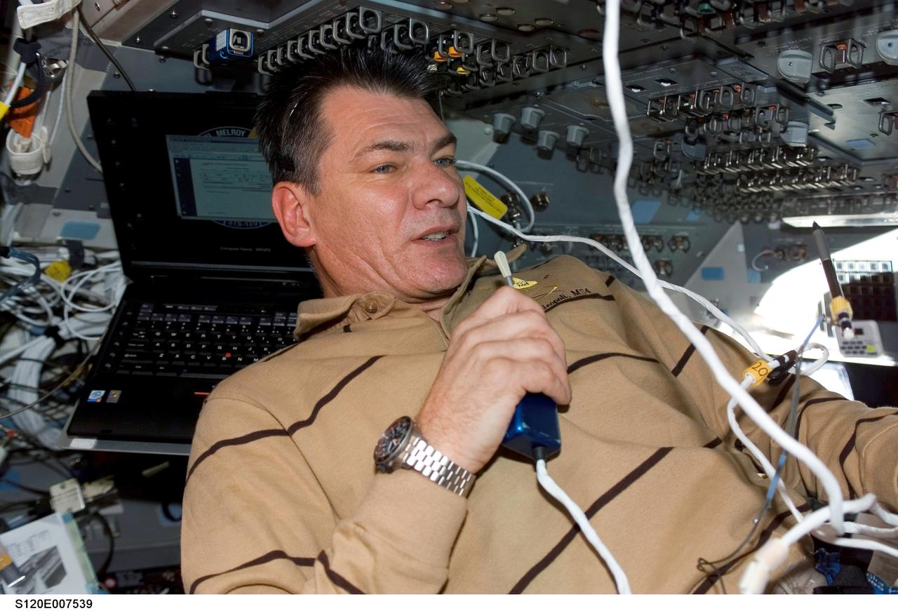 S120-E-007539 (30 Oct. 2007) --- European Space Agency (ESA) astronaut Paolo Nespoli, STS-120 mission specialist, uses a communication system on the flight deck of Space Shuttle Discovery during flight day eight activities while docked with the International Space Station.