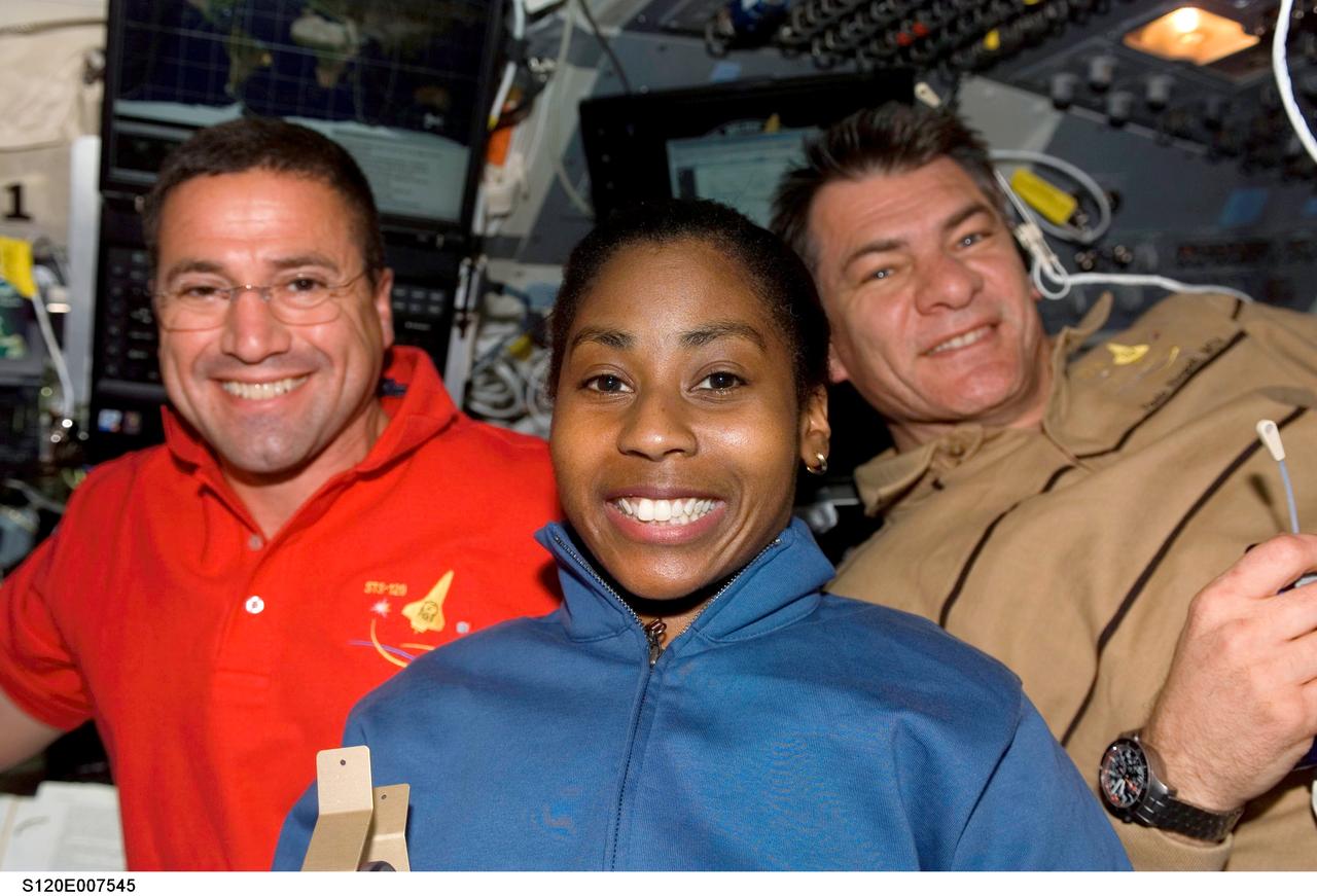 View of Astronauts George Zamka (red shirt),STS-120 pilot, Stephanie Wilson, STS-120 Mission specialist, and Paolo Nespoli, STS-120 Mission specialist representing the European Space Agency (ESA), as they pose for a photo on the flight deck of Space Shuttle Discovery during flight day eight activities while docked with the International Space Station.