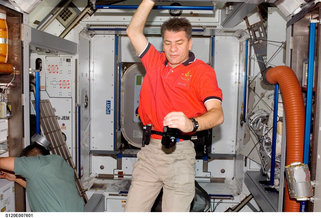 S120-E-007601 (31 Oct. 2007) --- European Space Agency (ESA) astronaut Paolo Nespoli (center), STS-120 mission specialist, and astronaut George Zamka, pilot, work in the Harmony node of the International Space Station while Space Shuttle Discovery is docked with the station.