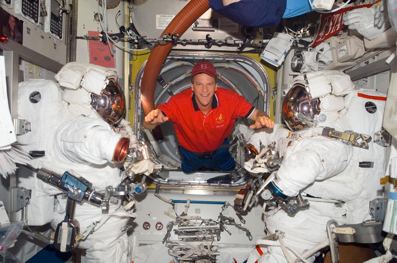 S120-E-007918 (1 Nov. 2007) --- Astronaut Scott Parazynski, STS-120 mission specialist, floats between two Extravehicular Mobility Unit (EMU) spacesuits in the Quest Airlock of the International Space Station while Space Shuttle Discovery is docked with the station.