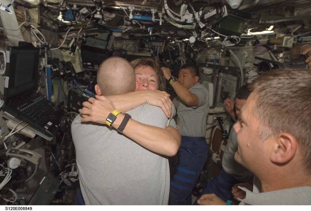 S120-E-008849 (4 Nov. 2007) --- Astronauts Peggy Whitson, Expedition 16 commander, and Clay Anderson, STS-120 mission specialist, exchange hugs during a farewell ceremony in the Destiny laboratory of the International Space Station (ISS). Also pictured are astronauts Doug Wheelock (right foreground), STS-120 mission specialist; George Zamka (partially obscured), pilot; and Daniel Tani, ISS flight engineer. Hatches were closed between the station and Space Shuttle Discovery at 2:03 p.m. (CST) on Nov. 4.