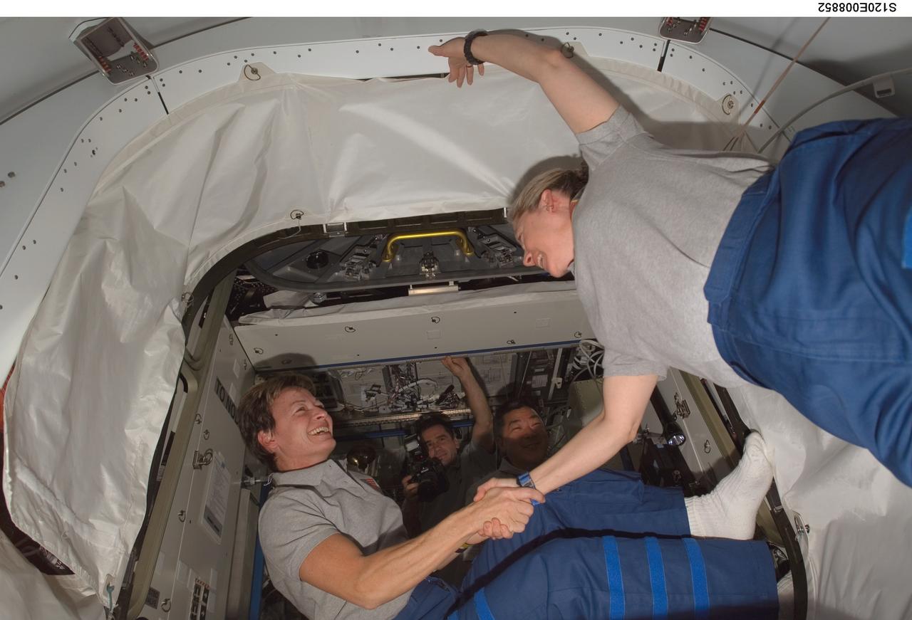 S120-E-008852 (4 Nov. 2007) --- Astronauts Peggy Whitson (left), Expedition 16 commander, and Pam Melroy, STS-120 commander, exchange handshakes in the Pressurized Mating Adapter (PMA-2) of the International Space Station as the STS-120 crewmembers exit the station to board Space Shuttle Discovery for their return trip home. Hatches were closed between the station and the shuttle at 2:03 p.m. (CST) on Nov. 4.