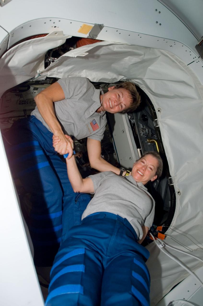 S120-E-008853 (4 Nov. 2007) --- Astronauts Peggy Whitson (left), Expedition 16 commander, and Pam Melroy, STS-120 commander, exchange handshakes in the Pressurized Mating Adapter (PMA-2) of the International Space Station as the STS-120 crewmembers exit the station to board Space Shuttle Discovery for their return trip home. Hatches were closed between the station and the shuttle at 2:03 p.m. (CST) on Nov. 4.