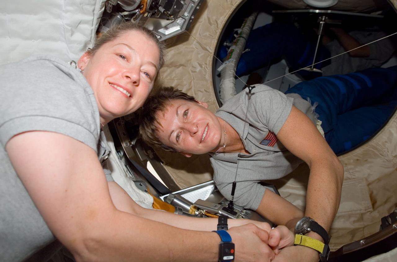 S120-E-008866 (4 Nov. 2007) --- Astronaut Pam Melroy (left), STS-120 commander, and Peggy Whitson, Expedition 16 commander, pose for a photo in the Pressurized Mating Adapter (PMA-2) of the International Space Station as the STS-120 crewmembers exit the station to board Space Shuttle Discovery for their return trip home. Hatches were closed between the station and the shuttle at 2:03 p.m. (CST) on Nov. 4.