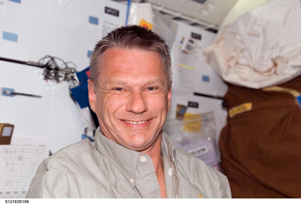 S121-E-05198 (5 July 2006) --- Astronaut Piers J. Sellers, STS-121 mission specialist, smiles for the camera as a crewmate photographs him on the middeck of the Space Shuttle Discovery. This was among the first group of digital still images showing the crewmembers onboard during their first full day in space.