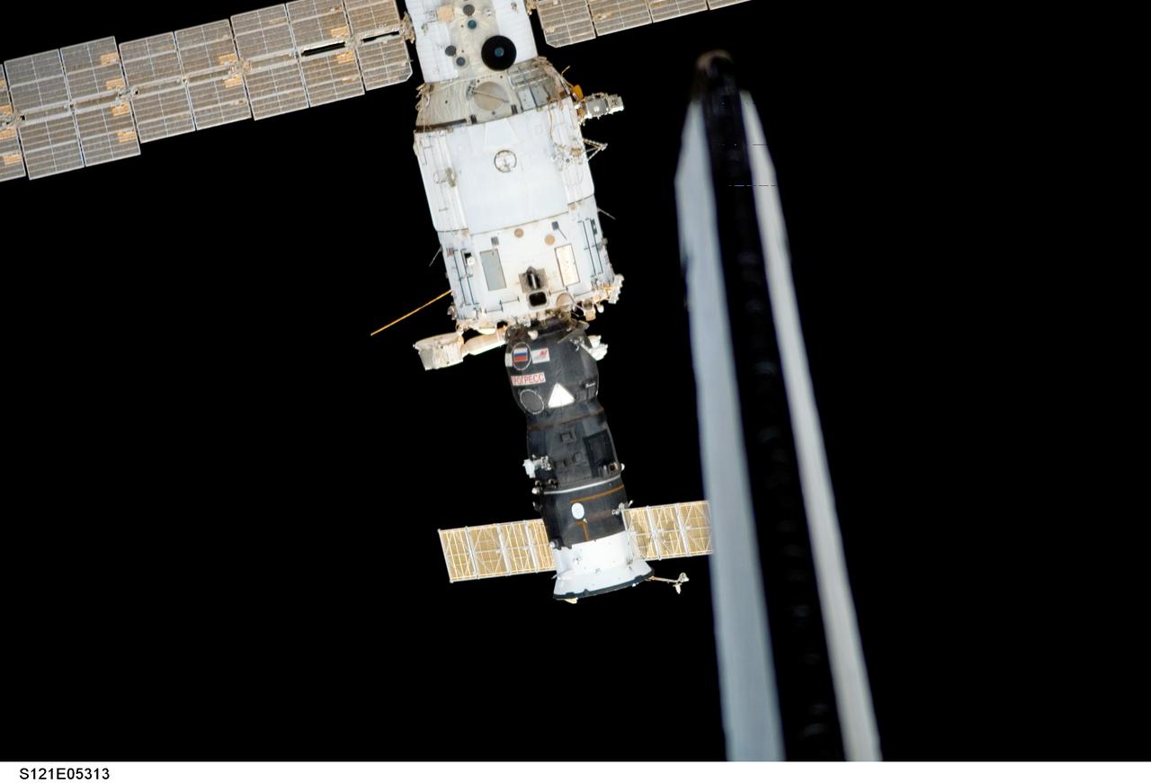 S121-E-05313 (6 July 2006) --- The vertical stabilizer of the Space Shuttle Discovery is in the foreground of this digital photo showing the International Space Station, as the spacecraft perform proximity operations. Progress 21 vehicle is seen docked to Zvezda.