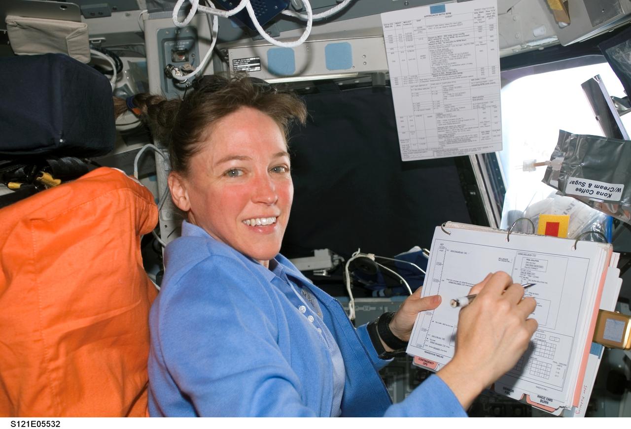 S121-E-05532 (6 July 2006) --- Astronaut Lisa M. Nowak logs data while temporarily occupying the commander's station on the flight deck of Discovery. The mission specialist and six crewmates were in the midst of one of their busiest days in space.