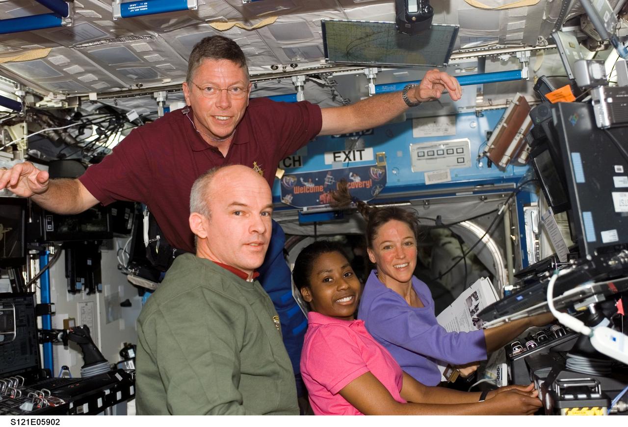 S121-E-05902 (7 July 2006) --- Astronaut Stephanie D. Wilson (center), STS-121 mission specialist, works with the Mobile Service System (MSS) and Canadarm2 controls in the Destiny laboratory of the International Space Station while Space Shuttle Discovery was docked to the station. Wilson used the station's arm to move the Italian-built Leonardo Multi-Purpose Logistics Module (MPLM) from the shuttle cargo bay to install on the station's Unity node. Astronauts Jeffrey N. Williams (foreground), Expedition 13 NASA space station science officer and flight engineer; Michael E. Fossum (top) and Lisa M. Nowak, STS-121 mission specialists, assisted Wilson. The MPLM was successfully latched in place by 7:15 a.m. (CDT) on July 7, 2006.
