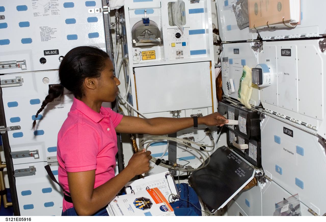 S121-E-05916 (7 July 2006) --- Astronaut Stephanie D. Wilson, STS-121 mission specialist, works with equipment on the middeck of the Space Shuttle Discovery while docked with the International Space Station.
