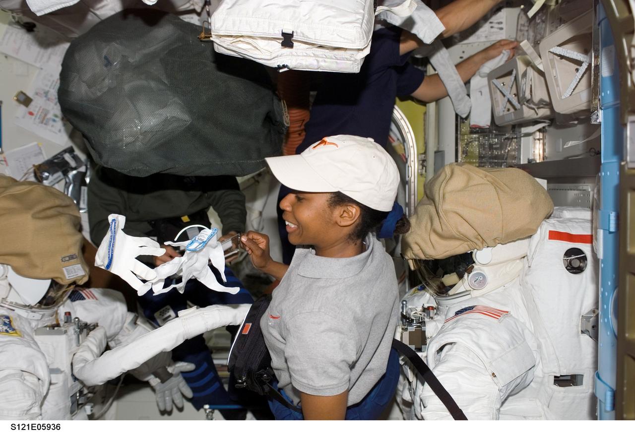 S121-E-05936 (8 July 2006) --- Astronaut Stephanie D. Wilson, STS-121 mission specialist, works with Extravehicular Mobility Unit (EMU) spacesuits in the Quest Airlock of the International Space Station while Space Shuttle Discovery was docked to the station.