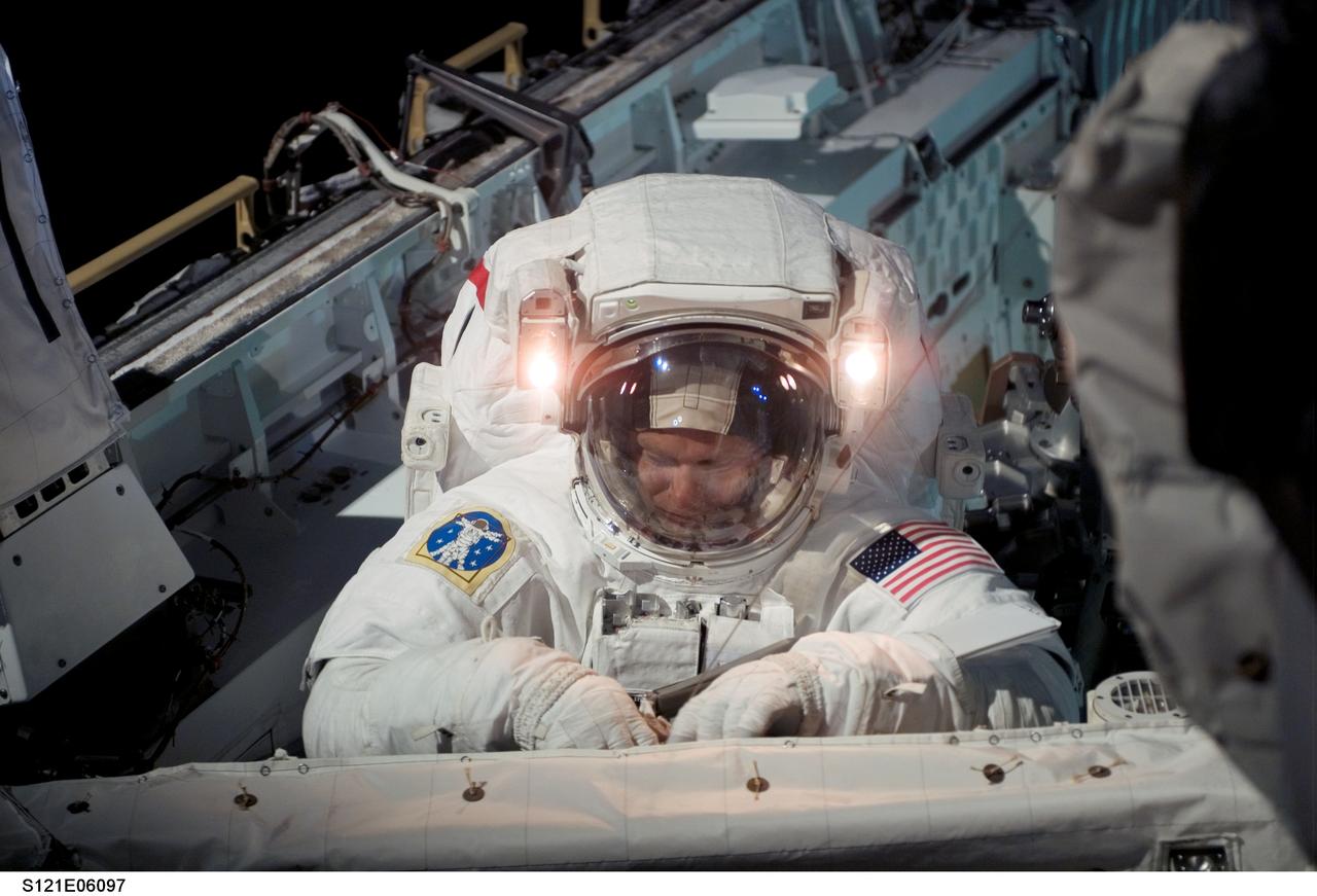 S121-E-06097 (8 July 2006) --- Astronaut Piers J. Sellers, STS-121 mission specialist, repositions tethers at the forward bulkhead of the Space Shuttle Discovery after completing the Orbiter Boom Sensor System (OBSS) evaluations during the mission's first session of extravehicular activity (EVA).