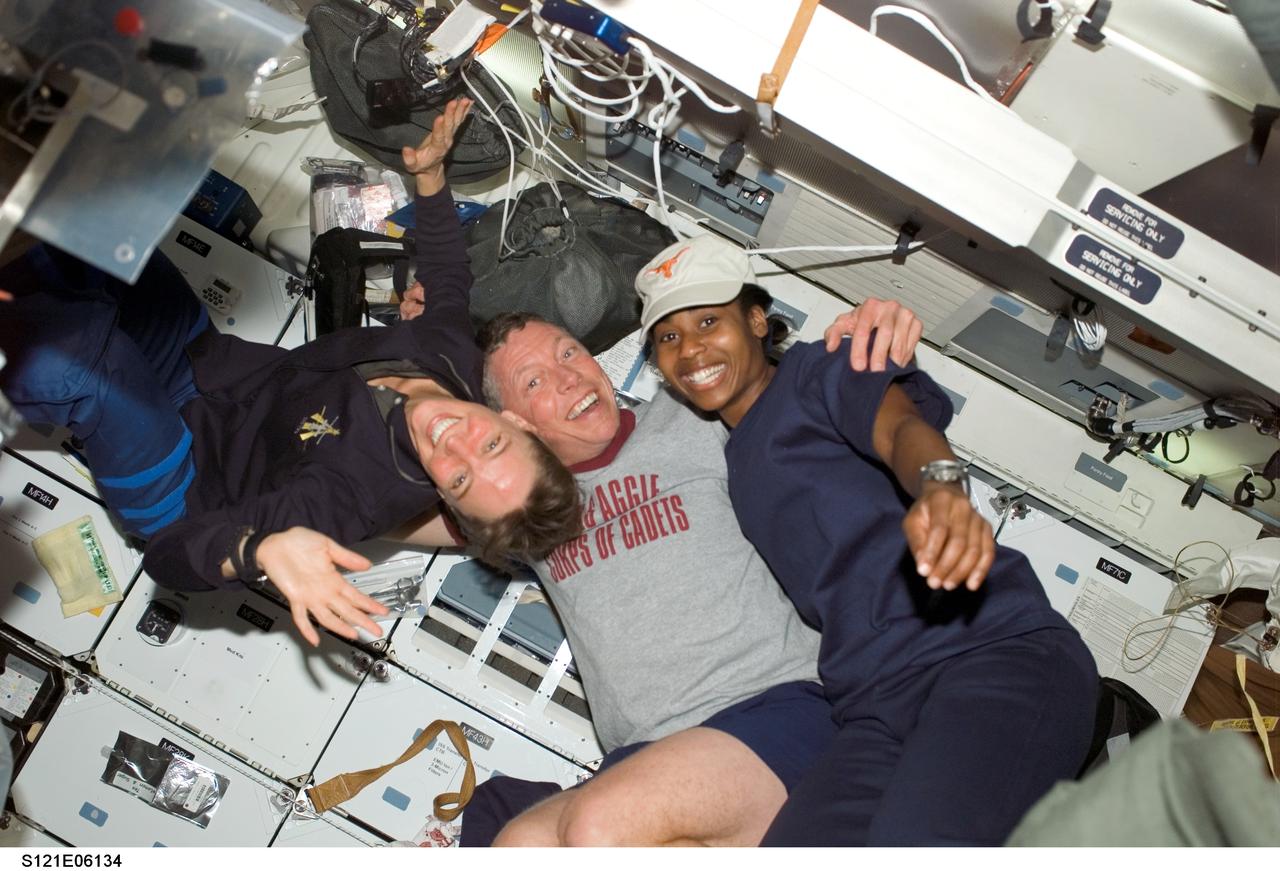 S121-E-06134 (8 July 2006) --- Astronaut Lisa M. Nowak (left), Michael E. Fossum and Stephanie D. Wilson, STS-121 mission specialists, enjoy a light moment on the middeck of the Space Shuttle Discovery while docked with the International Space Station.