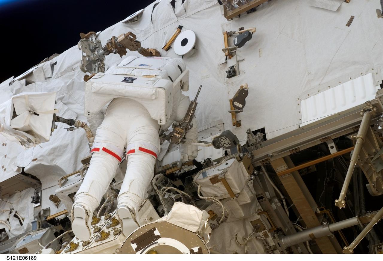 S121-E-06189 (10 July 2006) --- Astronaut Piers J. Sellers, STS-121 mission specialist, participates in the mission's second session of extravehicular activity (EVA). During today's six-hour 47-minute spacewalk, Sellers and astronaut Michael E. Fossum (out of frame), mission specialist, restored the International Space Station's Mobile Transporter rail car to full operation and delivered a spare pump module for the station's cooling system.