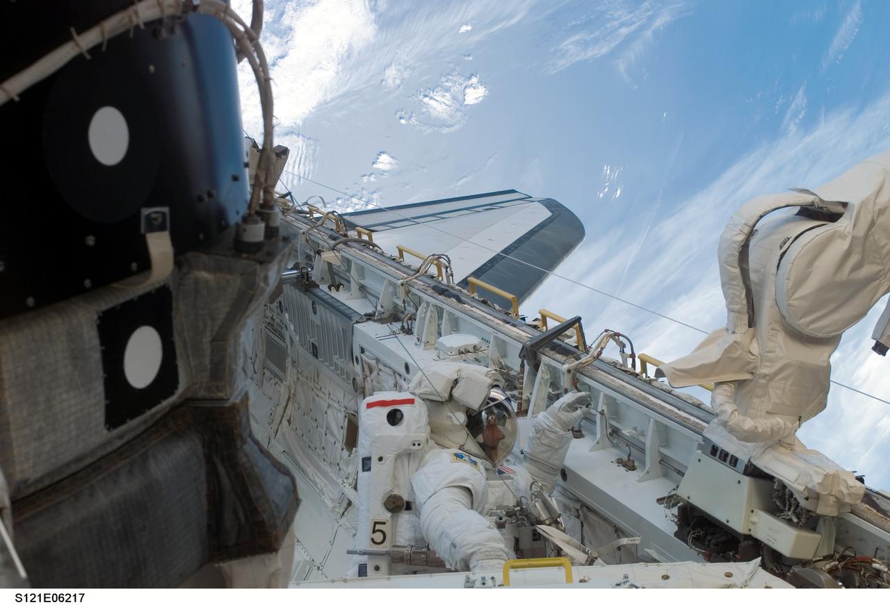 S121-E-06217 (10 July 2006) --- Astronaut Piers J. Sellers, STS-121 mission specialist, works in the Space Shuttle Discovery's cargo bay during the mission's second session of extravehicular activity (EVA). During today's six-hour 47-minute spacewalk, Sellers and astronaut Michael E. Fossum (out of frame), mission specialist, restored the International Space Station's Mobile Transporter rail car to full operation and delivered a spare pump module for the station's cooling system.