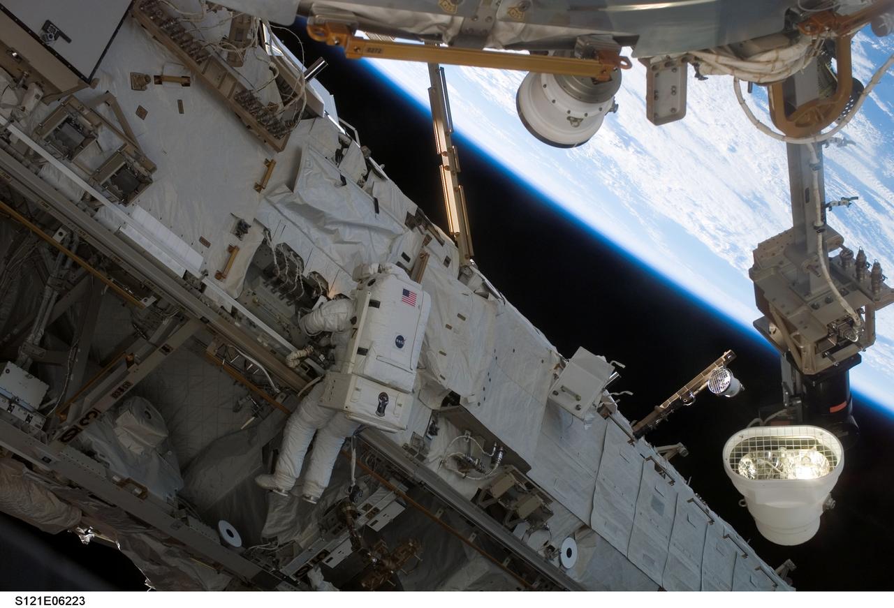 S121-E-06223 (10 July 2006) --- Astronaut Michael E. Fossum, STS-121 mission specialist, participates in the mission's second session of extravehicular activity (EVA). During today's six-hour 47-minute spacewalk, Fossum and astronaut Piers J. Sellers (out of frame), mission specialist, restored the International Space Station's Mobile Transporter rail car to full operation and delivered a spare pump module for the station's cooling system.