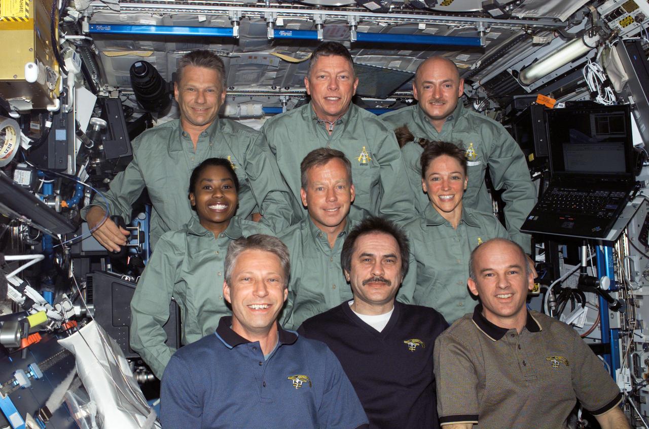 S121-E-06239 (9 July 2006) --- The STS-121 (green shirts) and Expedition 13 crewmembers gather for a group photo in the Destiny laboratory of the International Space Station. From the left (front row) are European Space Agency (ESA) astronaut Thomas Reiter of Germany, Expedition 13 flight engineer; cosmonaut Pavel V. Vinogradov, commander representing Russia's Federal Space Agency; and astronaut Jeffrey N. Williams, NASA space station science officer and flight engineer. From the left (middle row) are astronauts Stephanie D. Wilson, STS-121 mission specialist; Steven W. Lindsey, commander; and Lisa M. Nowak, mission specialist. From the left (back row) are astronauts Piers J. Sellers, Michael E. Fossum, both mission specialists; and Mark E. Kelly, pilot.