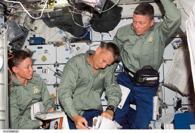 NASA image: Nowak, Sellers and Fossum look over Crew Notebooks during STS-121 / Expedition 13 joint operations
