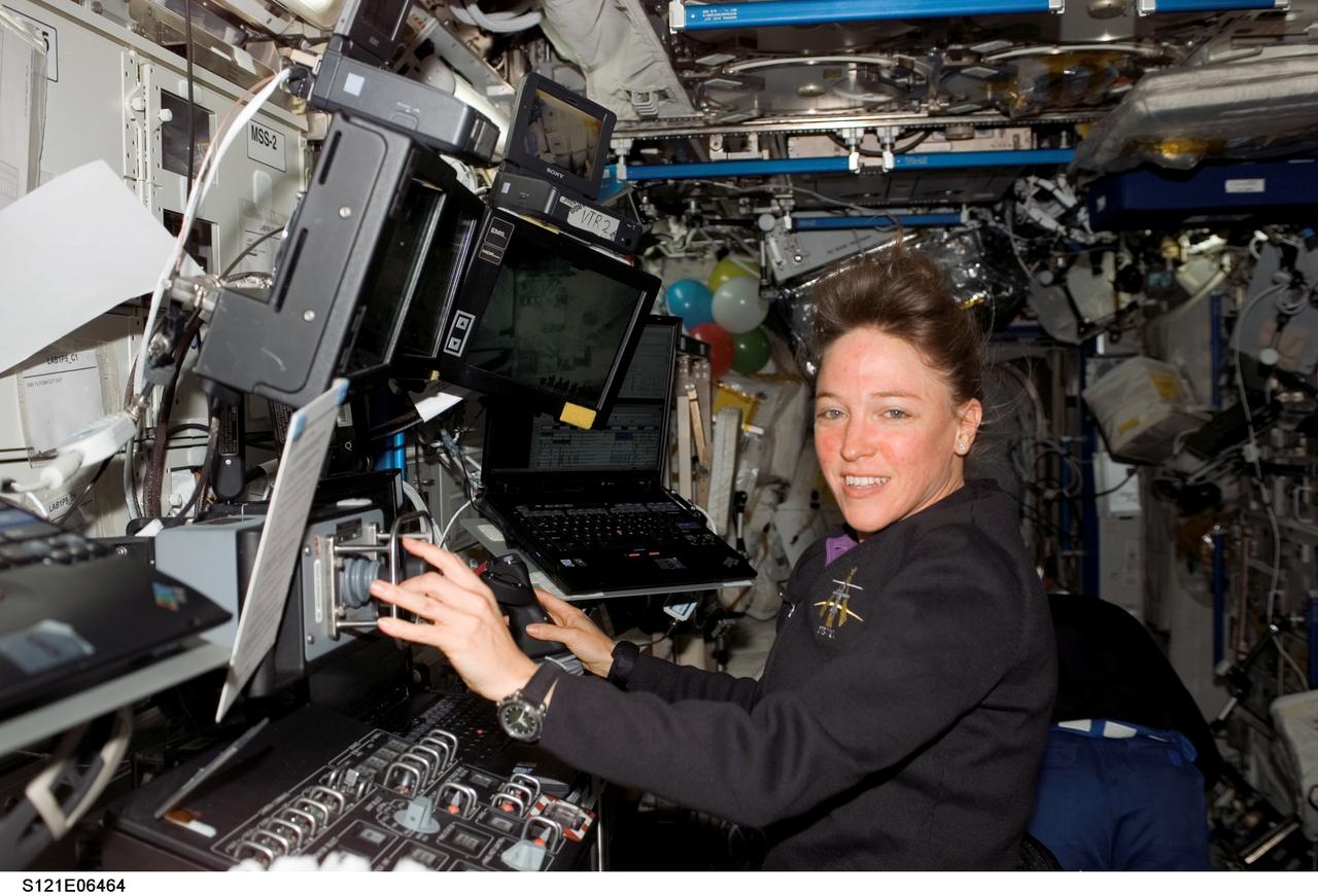 S121-E-06464 (12 July 2006) --- Astronaut Lisa M. Nowak, STS-121 mission specialist, works with the Mobile Service System (MSS) and Canadarm2 controls in the Destiny laboratory of the International Space Station while Space Shuttle Discovery was docked to the station.