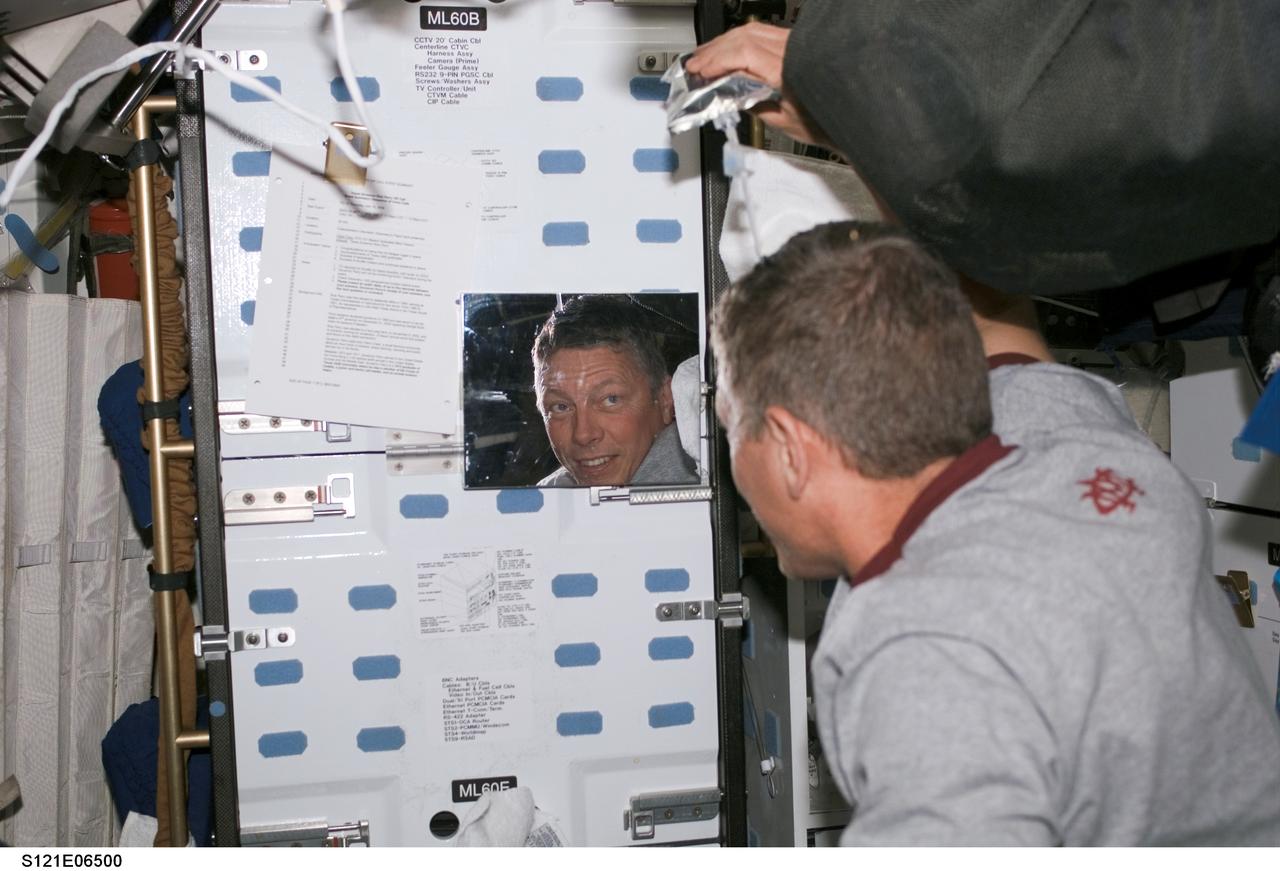 S121-E-06500 (13 July 2006) --- Astronaut Michael E. Fossum, STS-121 mission specialist, prepares to wash his hair on the middeck of the Space Shuttle Discovery while docked with the International Space Station.