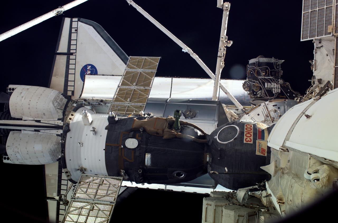 S121-E-06540 (13 July 2006) --- This scene, photographed from the International Space Station while docked with Space Shuttle Discovery, shows the orbiter, the orbiter's Remote Manipulator System (RMS) arm, the Space Station RMS (Canadarm2), the Orbiter Boom and Sensor System (OBSS) and a Soyuz vehicle docked with the orbital outpost.