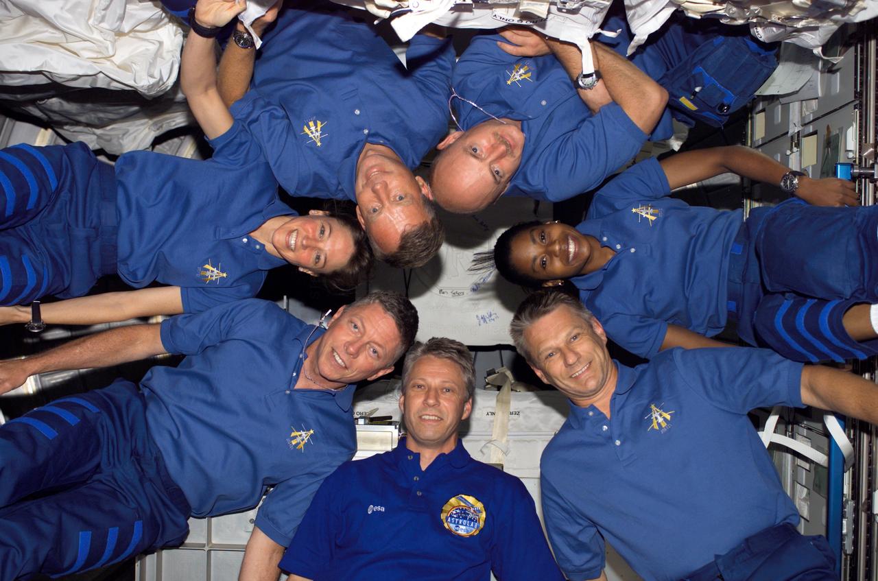 S121-E-07024 (13 July 2006) --- European Space Agency (ESA) astronaut Thomas Reiter (bottom center), Expedition 13 flight engineer, and the STS-121 crewmembers pose in "star-burst" formation for an in-flight portrait in the Destiny laboratory of the International Space Station while Space Shuttle Discovery was docked with the station. Clockwise, around the circle from Reiter, are astronauts Michael E. Fossum, Lisa M. Nowak, both mission specialists; Steven W. Lindsey and Mark E. Kelly, commander and pilot, respectively; Stephanie D. Wilson and Piers J. Sellers, mission specialists. Reiter launched on the Space Shuttle Discovery with the STS-121 crew and officially became an Expedition 13 crewmember after the shuttle docked with the station.