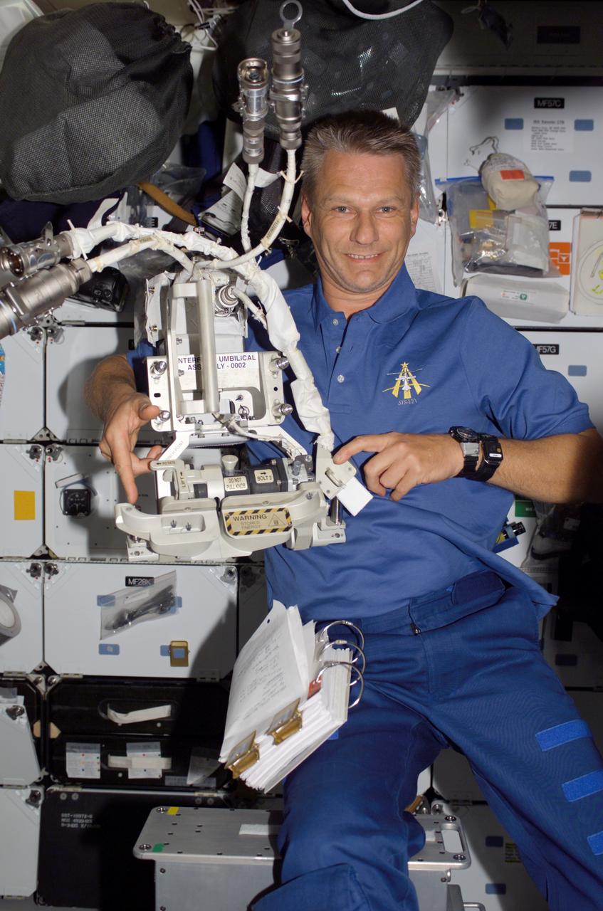 S121-E-07087 (13 July 2006) --- Astronaut Piers J. Sellers, STS-121 mission specialist, holds an interface umbilical assembly (IUA) on the middeck of Space Shuttle Discovery. The IUA was replaced during Flight Day 5 extravehicular activity (EVA) while the shuttle was docked with the International Space Station.