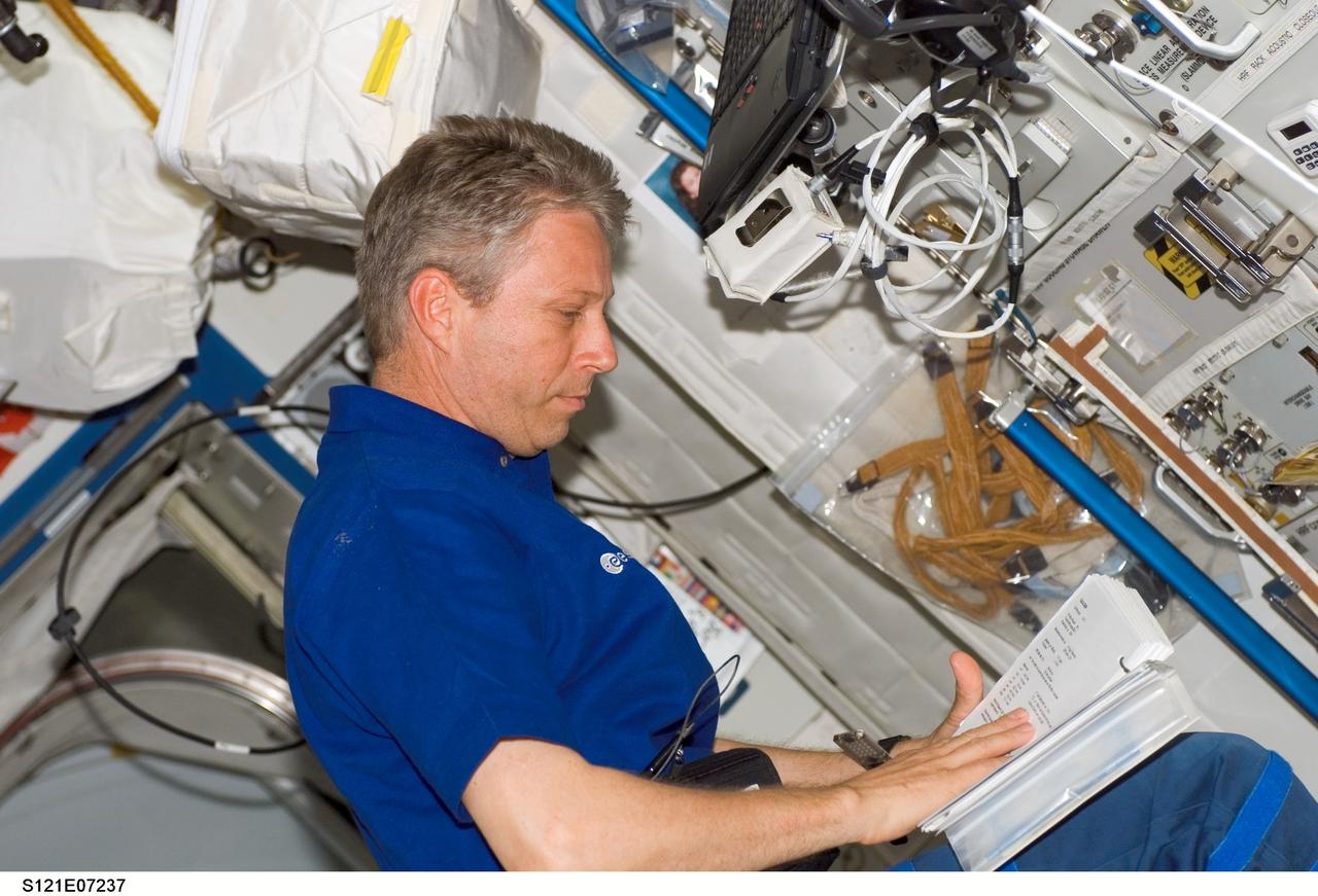 S121-E-07237 (13 July 2006) --- European Space Agency (ESA) astronaut Thomas Reiter, Expedition 13 flight engineer, looks over a procedures checklist in the Destiny laboratory of the International Space Station while Space Shuttle Discovery was docked with the station. Reiter launched on Discovery with the STS-121 crew and officially became an Expedition 13 crewmember after the shuttle docked with the station.