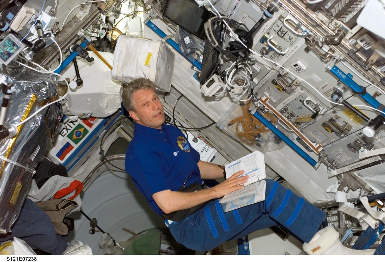 S121-E-07238 (13 July 2006) --- European Space Agency (ESA) astronaut Thomas Reiter, Expedition 13 flight engineer, looks over a procedures checklist in the Destiny laboratory of the International Space Station while Space Shuttle Discovery was docked with the station. Reiter launched on Discovery with the STS-121 crew and officially became an Expedition 13 crewmember after the shuttle docked with the station.
