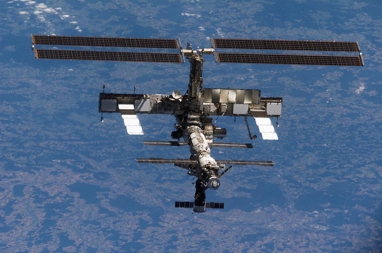 S121-E-07571 (15 July 2006) --- Backdropped against a colorful Earth, the International Space Station moves away from Space Shuttle Discovery. Earlier the STS-121 and Expedition 13 crews concluded almost nine days of cooperative work onboard the shuttle and station. Undocking of the two spacecraft occurred at 5:08 a.m. (CDT) on July 15, 2006.