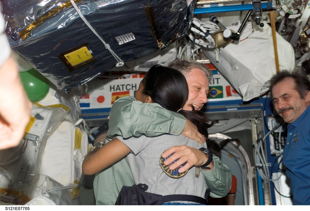 S121-E-07705 (15 July 2006) --- Astronaut Stephanie D. Wilson, STS-121 mission specialist, and European Space Agency (ESA) astronaut Thomas Reiter, Expedition 13 flight engineer, bid farewell to one another prior to the undocking of the Space Shuttle Discovery and the International Space Station. Cosmonaut Pavel V. Vinogradov, Expedition 13 commander representing Russia's Federal Space Agency, is at right.