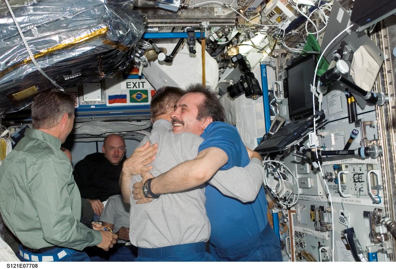 S121-E-07708 (15 July 2006) --- Astronaut Piers J. Sellers, STS-121 mission specialist, and cosmonaut Pavel V. Vinogradov, Expedition 13 commander representing Russia's Federal Space Agency, bid farewell to one another prior to the undocking of the Space Shuttle Discovery and the International Space Station. European Space Agency (ESA) astronaut Thomas Reiter (left) and astronaut Mark E. Kelly (background), STS-121 pilot, are also pictured.