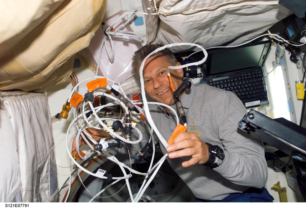 S121-E-07791 (15 July 2006) --- Astronaut Piers J. Sellers, STS-121 mission specialist, works with cables on the middeck of Space Shuttle Discovery as the shuttle crew prepares to undock from the International Space Station.