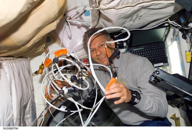 NASA image: Sellers holds up a bundle of tangled audio cables during  STS-121 / Expedition 13 joint operations