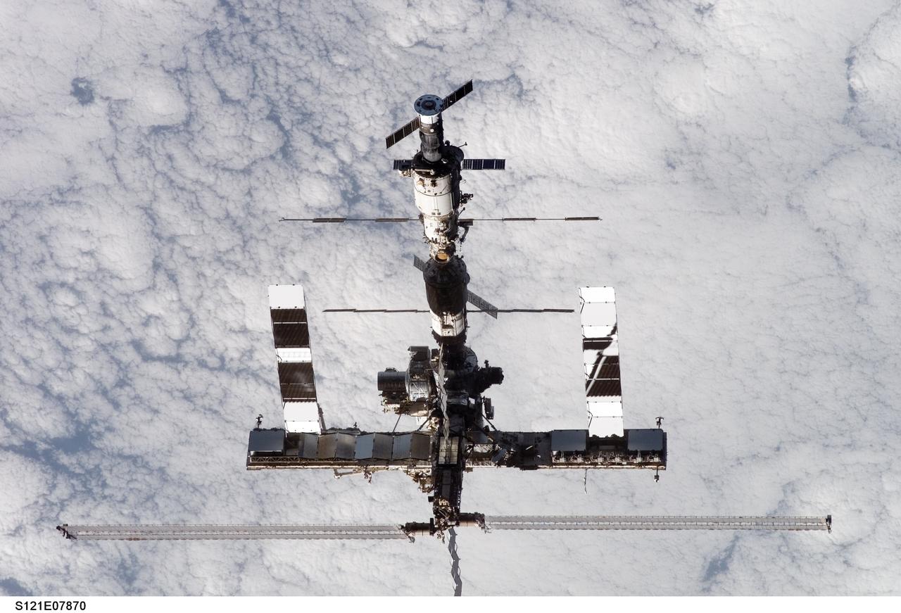 S121-E-07870 (15 July 2006) --- Backdropped by a cloud-covered Earth, the International Space Station moves away from Space Shuttle Discovery. Earlier the STS-121 and Expedition 13 crews concluded almost nine days of cooperative work onboard the shuttle and station. Undocking of the two spacecraft occurred at 5:08 a.m. (CDT) on July 15, 2006.