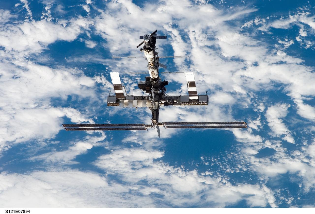 S121-E-07894 (15 July 2006) --- Backdropped by a blue and white Earth, the International Space Station moves away from Space Shuttle Discovery. Earlier the STS-121 and Expedition 13 crews concluded almost nine days of cooperative work onboard the shuttle and station. Undocking of the two spacecraft occurred at 5:08 a.m. (CDT) on July 15, 2006.