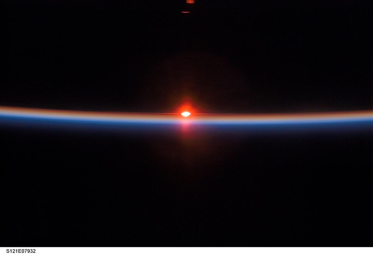 S121-E-07932 (15 July 2006) --- A setting sun and the thin blue airglow line at Earth's horizon were captured in this image photographed by an STS-121 crewmember aboard the Space Shuttle Discovery.