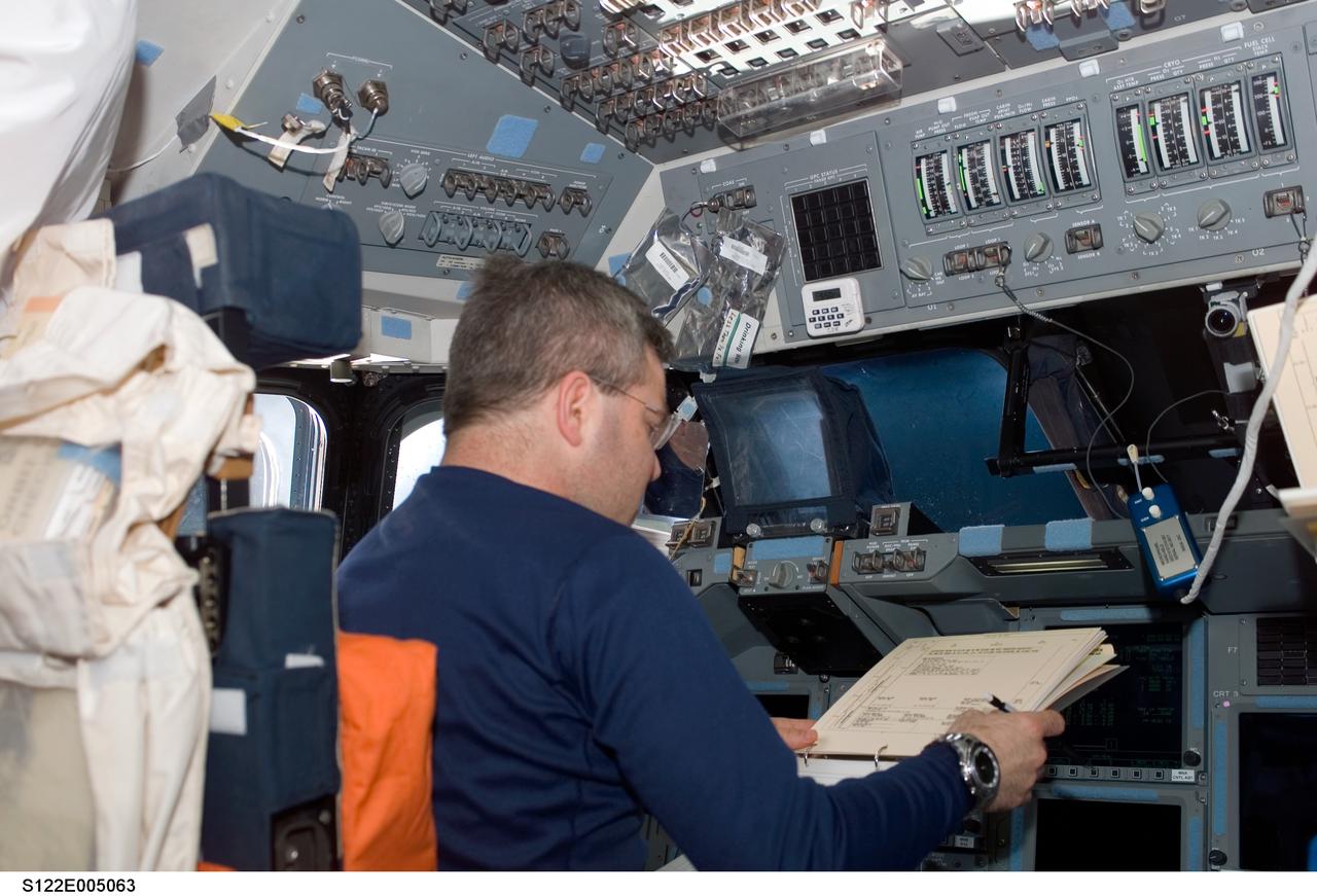 S122-E-005063 (7 Feb. 2008) --- Astronaut Steve Frick, STS-122 commander, looks over procedures checklists on the flight deck of Space Shuttle Atlantis during flight day one activities.