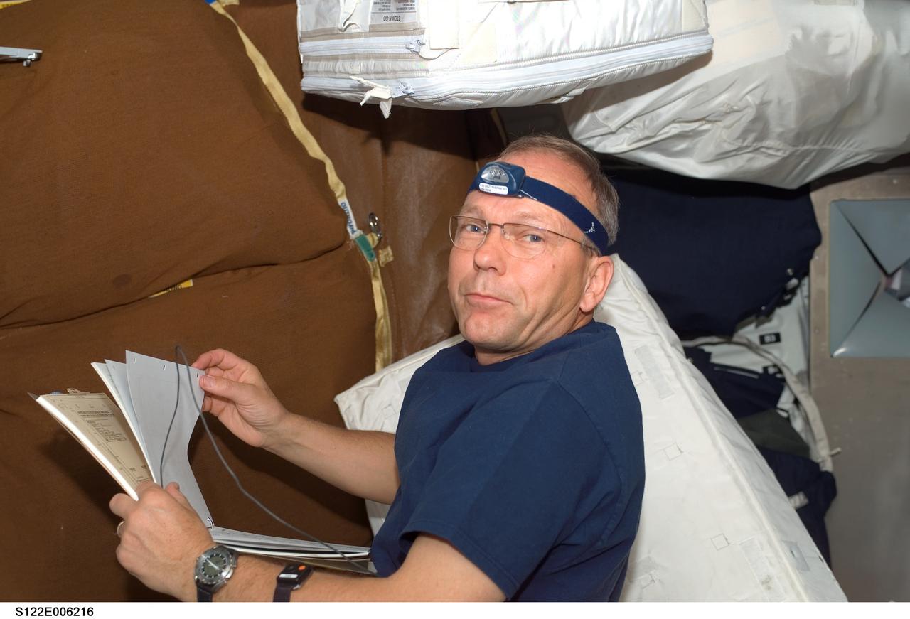S122-E-006216 (8 Feb. 2008) --- European Space Agency (ESA) astronaut Hans Schlegel, STS-122 mission specialist, is surrounded by equipment and supplies destined for the International Space Station while working on the middeck of Space Shuttle Atlantis during flight day two activities.