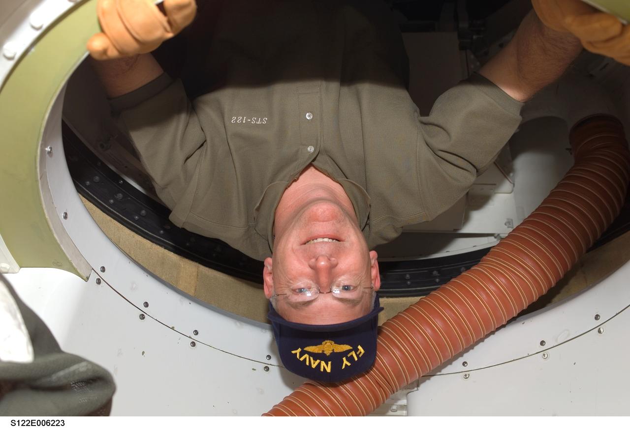 S122-E-006223 (8 Feb. 2008) --- Astronaut Alan Poindexter, STS-122 pilot, passes through a tunnel on the Space Shuttle Atlantis on the eve of the docking of the shuttle to the International Space Station.