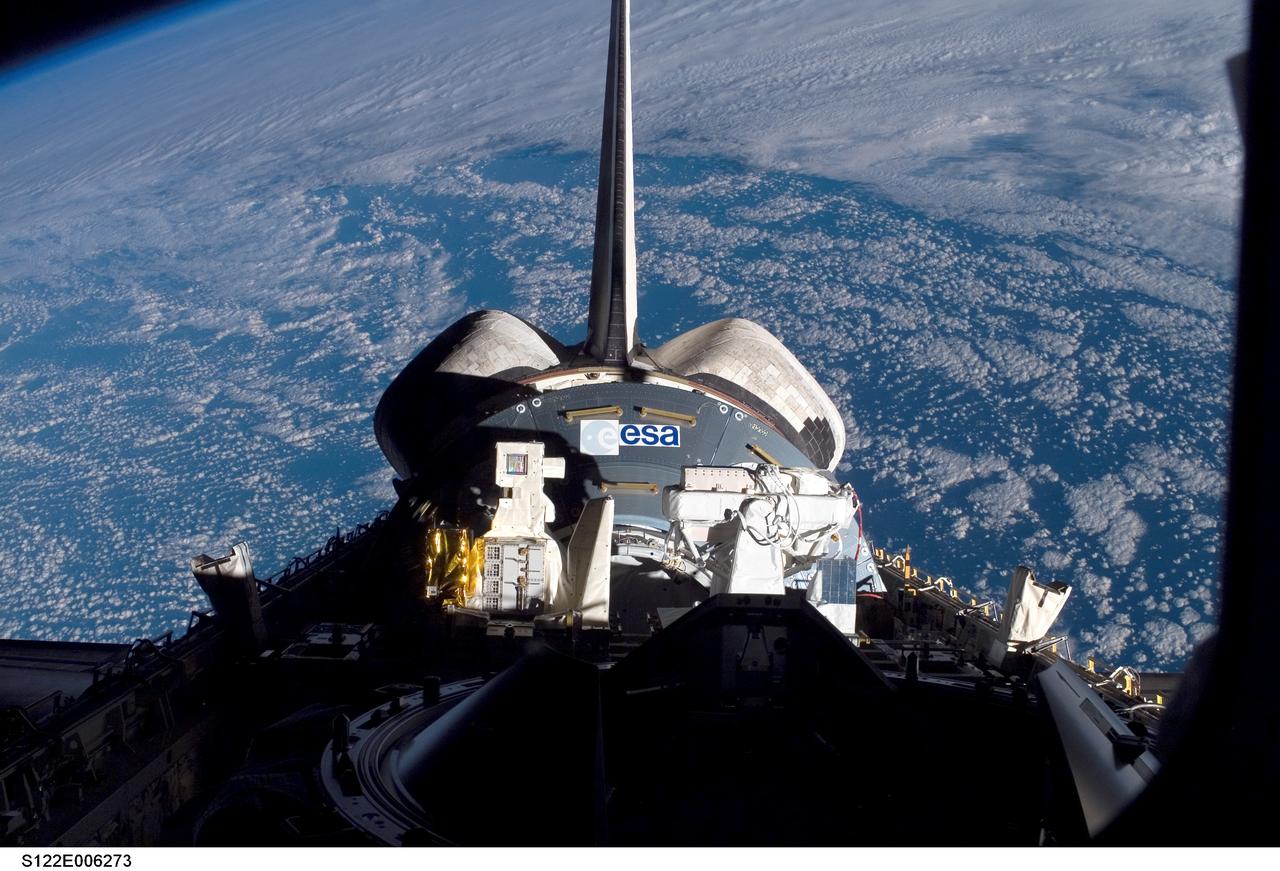 S122-E-006273 (8 Feb. 2008) --- Backdropped against a cloud-covered portion of Earth, the European Space Agency's Columbus laboratory and associated ESA hardware sit in the aft section of Space Shuttle Atlantis' cargo bay on the eve of the shuttle's scheduled docking to the International Space Station. The addition of Columbus to the orbital outpost is one of the primary tasks of the STS-122 mission.