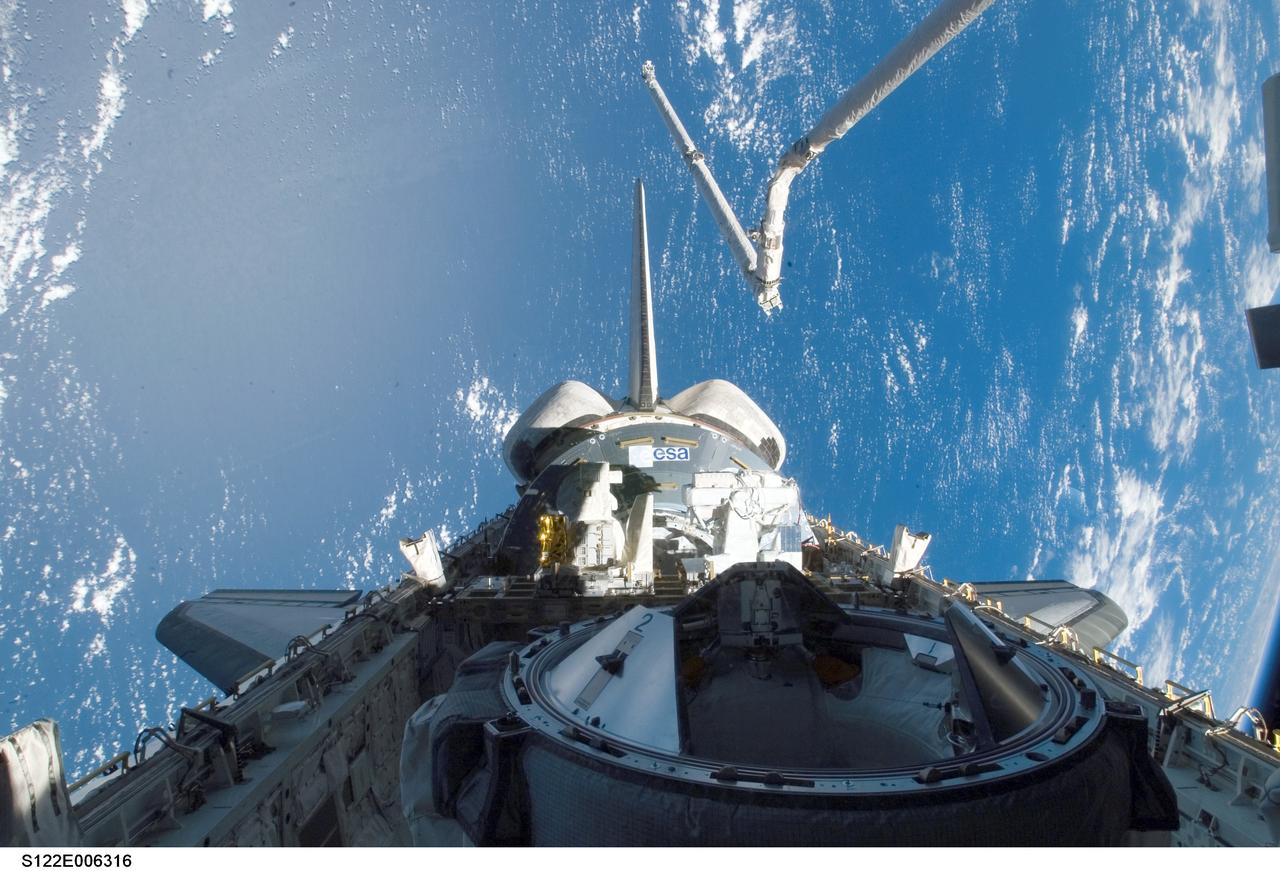 S122-E-006316 (8 Feb. 2008) --- Backdropped by a blue and white Earth, the docking mechanism (foreground), Columbus laboratory in Space Shuttle Atlantis' aft payload bay, vertical stabilizer, orbital maneuvering system (OMS) pods and Atlantis' Remote Manipulator System/Orbiter Boom Sensor System (RMS/OBSS) are featured in this image photographed by a STS-122 crewmember during flight day two activities.