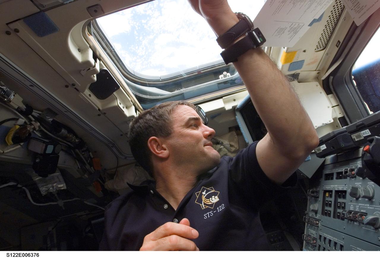 S122-E-006376 (8 Feb. 2008) --- Astronaut Rex Walheim, STS-122 mission specialist, does not have a shortage of windows from which to view Earth's horizon or steal a glance into space from his position on the aft end of Space Shuttle Atlantis' crew cabin.